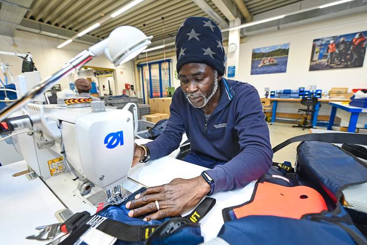 Hochwertige Handarbeit: In der Schneiderei bearbeitet Näher Idrissa Kanté eine Rettungsweste für die spanische Marine. Foto: KAUTSCHUK/Christian Augustin